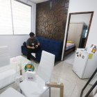 Departamento. Una persona está en su sala - comedor, que se ve pequeña, así como el dormitorio.