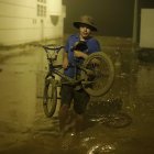 Pobladores de Punta Hermosa al sur de Lima, caminan en el lodo que inundó las calles hoy martes 14 de marzo en Lima (Perú).