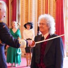 Brian May en instantes en que es reconocido por Carlos III de Inglaterra.