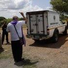 El monseñor José Luis Lacunza bendice los vehículos donde se encuentran los cuerpos de migrantes fallecidos durante un accidente en autobús el pasado mes de febrero, hoy en David (Panamá).