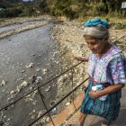 Una mujer cruza el río Las Vacas que transporta cientos de toneladas de basura, el 13 de febrero 2023, provenientes de la Ciudad de Guatemala, en Chinautla (Guatemala).