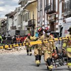 Miembros de los bomberos ayudan con los daños ocasionados por el sismo de magnitud 6,5 en la escala abierta de Richter hoy, en la ciudad de Cuenca (Ecuador).