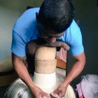 Oficio. Simón ubica el atado de hebras de toquilla (palmera autóctona) en la horma de madera, en forma de queso, sobre la que se coloca una almohada para apoyar el pecho y empezar el tejido del sombrero.