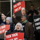 Manifestantes gritan y sostienen carteles frente al Tribunal Penal de Nueva York antes de una posible acusación contra el expresidente Donald Trump en Nueva York, Nueva York.