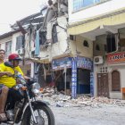 AME3860. PASAJE (ECUADOR), 19/03/2023.- Una pareja en motocicleta pasa hoy, frente a una edificación afectada por un terremoto de magnitud 6,5 en la ciudad de Pasaje (Ecuador). A 446 ascendió la cifra de heridos por el sismo de magnitud 6,5 en la escala abierta de Richter, que se registró el sábado en la provincia del Guayas, en la zona costera de Ecuador, y que dejó 14 fallecidos. EFE/Jhonatan Miranda
