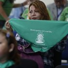 Una mujer muestra hoy una pañoleta verde con la imagen de Beatriz, mientras observa la transmisión en vivo de una audiencia de la CorteIDH, en San Salvador (El Salvador). EFE/Rodrigo Sura