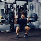 A strong man doing deadlift with weights in a gym.