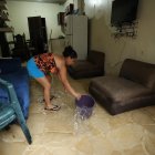 Inundación. Una ama de casa saca el agua que se metió a su casa por la lluvia y aguaje que hubo en Guayaquil, sus enseres se afectaron.