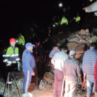 Bomberos de Alausí intentan rescatar a personas atrapadas bajo una de las casas.