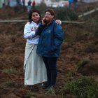 Familiares se lamentan hoy en la zona donde se presentó un deslizamiento de tierra, en Alausí (Ecuador).