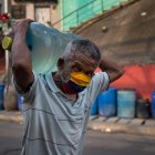 Caracas. Un hombre al cargar un botellón de agua potable suministrado por un camión cisterna en un barrio popular de esta capital sudamericana.