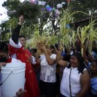 Un sacerdote bendice a los feligreses durante la celebración del Domingo de Ramos.