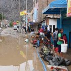 Residentes intentan sacar el agua de sus casas y locales inundados por el ciclón Yaku, en el distrito de Chaclacayo, en Lima.