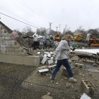Una mujer pasa frente a un negocio destruido tras un tornado en Belvidere, Illinois, EE.UU.