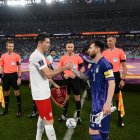 Lewandowski (i) y Messi estrechan saludo durante la Copa del Mundo de Qatar 2022.
