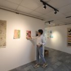Arte. Mikaela Báez, curadora y una de los artistas participantes en la muestra, acomoda una de las obras.