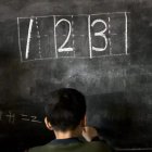 Aulas. Un niño hace ejercicios de matemáticas en la pizarra.