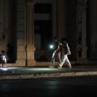 Personas caminan por una calle sin iluminación auxiliándose con la luz de su celular durante un apagón, en La Habana (Cuba).