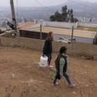 Recorrido. Emilia Venegas (d), dirigente comunitaria, y María Paz Valdivia, de la ONG, caminan por una calle local.