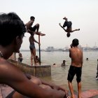 Niños indios saltan al río Ganges mientras se refrescan durante una calurosa tarde en Calcuta, India, el 18 de abril de 2023.