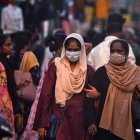 Dos mujeres con mascarilla pasan por una calle llena de gente en Chennai, India, el 11 de abril de 2023. EFE/EPA/IDREES MOHAMMED