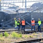 Trabajadores junto al tren de mercancías descarrilado cerca de una estación en la ciudad italiana de Florencia.
