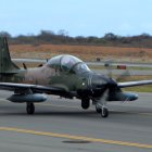 Archivo. Un avión Supertucano y uniformados de la FAE.