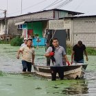 En Santa Lucía, un grupo traslada en una canoa los electrodomésticos desde un sector anegado.