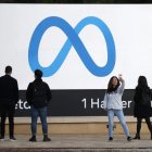 Símbolo.- Un grupo de personas ante el logo de la empresa Meta.