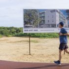 Un hombre pasa frente a una publicidad de venta de obra nueva en Maó, Menorca, este lunes.