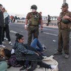 Policías hablan con migrantes en el paso fronterizo de control entre Santa Rosa (Perú) y Chacalluta (Chile), el jueves 27 de abril de 2023. El presidente del Congreso de Chile, Vlado Mirosevic, lanzó este viernes la idea de crear "un corredor" humanitario para solucionar la crisis migratoria en la frontera norte, donde cientos de personas se agolpan desde hace dos días tratando de salir de Chile e ingresar en Perú de forma irregular. EFE/ Aldair Mejía