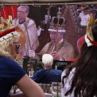 Un grupo de turistas británicos este sábado en Magaluf (Calviá, Baleares), sigue en directo la coronación del rey Carlos III, con coronas de juguete en la cabeza.