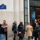Varias personas esperan en la puerta de una tienda de lujo este sábado en París.