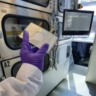 Uno de los miembros del equipo que trabaja en el rediseño de la celda de batería de litio-aire sostiene parte del equipamiento empleado en la investigación.