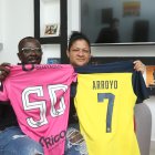 Silvia Alvarado y Grober Arroyo sostienen con orgullo las camisetas de su hijo Kenny Arroyo.