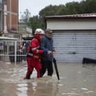 Un miembro de la Cruz Roja Italiana ayuda a las personas a salir de sus apartamentos tras la crecida del río Savio, en Cesena, Italia, el 16 de mayo de 2023.