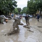 Personas trabajan para limpiar una calle anegada tras las inundaciones que están afectando a la región de Emilia-Romaña, en Faenza, Italia, el 19 de mayo de 2023.