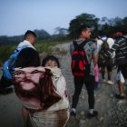Adultos y niños migrantes hacen fila en la comunidad de Bajo Chiquito para ser trasladados a la Estación de Recepción Migratoria (ERM) de San Vicente, en Metetí (Panamá), en una fotografía de archivo.