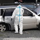 Un agente especializado revisa el vehículo en el que se movilizaba el agente de tránsito y un acompañante.