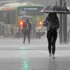 Una mujer joven camina bajo fuertes lluvias en Tokio, Japón, el 2 de junio de 2023. El aire cálido y húmedo generado por el tifón Mawar fluyó hacia el frente de la temporada de lluvias