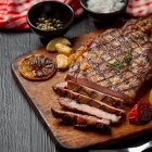 Grilled beef steak on the dark wooden background.