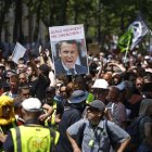 Manifestantes sostienen una imagen del presidente Emmanuel Macron durante protestas en París contra la reforma a las pensiones que impulsa el Ejecutivo.