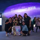 Turistas extranjeros se toman una foto frente a Dongdaemun Design Plaza en Seúl, Corea del Sur, iluminado de púrpura la noche del 12 de junio de 2023, como parte de un festival de dos semanas para celebrar el décimo aniversario de la sensación mundial del K-pop BTS debut, que cae el 13 de junio.