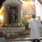 El padre Carlos Mena junto a la imagen de San Miguel.