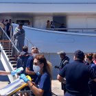 Paramédicos del Servicio Nacional de Ambulancias de Emergencia (EKAV) de Grecia y miembros de la Cruz Roja griega ayudan a los migrantes a su llegada al puerto de Kalamata, Grecia