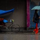 una mujer caminando bajo la lluvia en Kathmandu (Nepal).