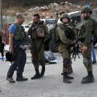 Oficiales de las fuerzas de seguridad israelíes hacen guardia junto al cuerpo de un presunto atacante en la escena de un tiroteo en el asentamiento de Eli, entre Nablus y Ramallah, en Cisjordania, el 20 de junio de 2023