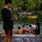 Beijing (China), 23/06/2023.- La gente se refresca a lo largo de un canal en Beijing, China, el 23 de junio de 2023. Beijing registró el 22 de junio el día más caluroso de junio con 41,1 grados centígrados