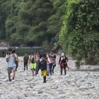 Migrantes de diversos países atraviesan una zona de piedras junto a un río en la zona del Darién, en Panamá