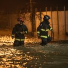 Bomberos caminan en la madrugada de hoy por calles anegadas por agua tras la crecida del río Cachapoal, producto de las intensas lluvias en la comuna de Coltauco (Chile). Miles de chilenos permanecen aislados o damnificados a causa de las lluvias torrenciales que se presentan desde el jueves pasado en el centro del país, una situación anormal producto de las altas temperaturas en las cimas de Los Andes, inusuales en este inicio del invierno austral, y que ya deja dos muertos y seis desaparecidos, dijeron este domingo las autoridades. EFE / Rafael Arancibia
